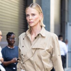 Charlize Theron wearing a tucked-in trench coat