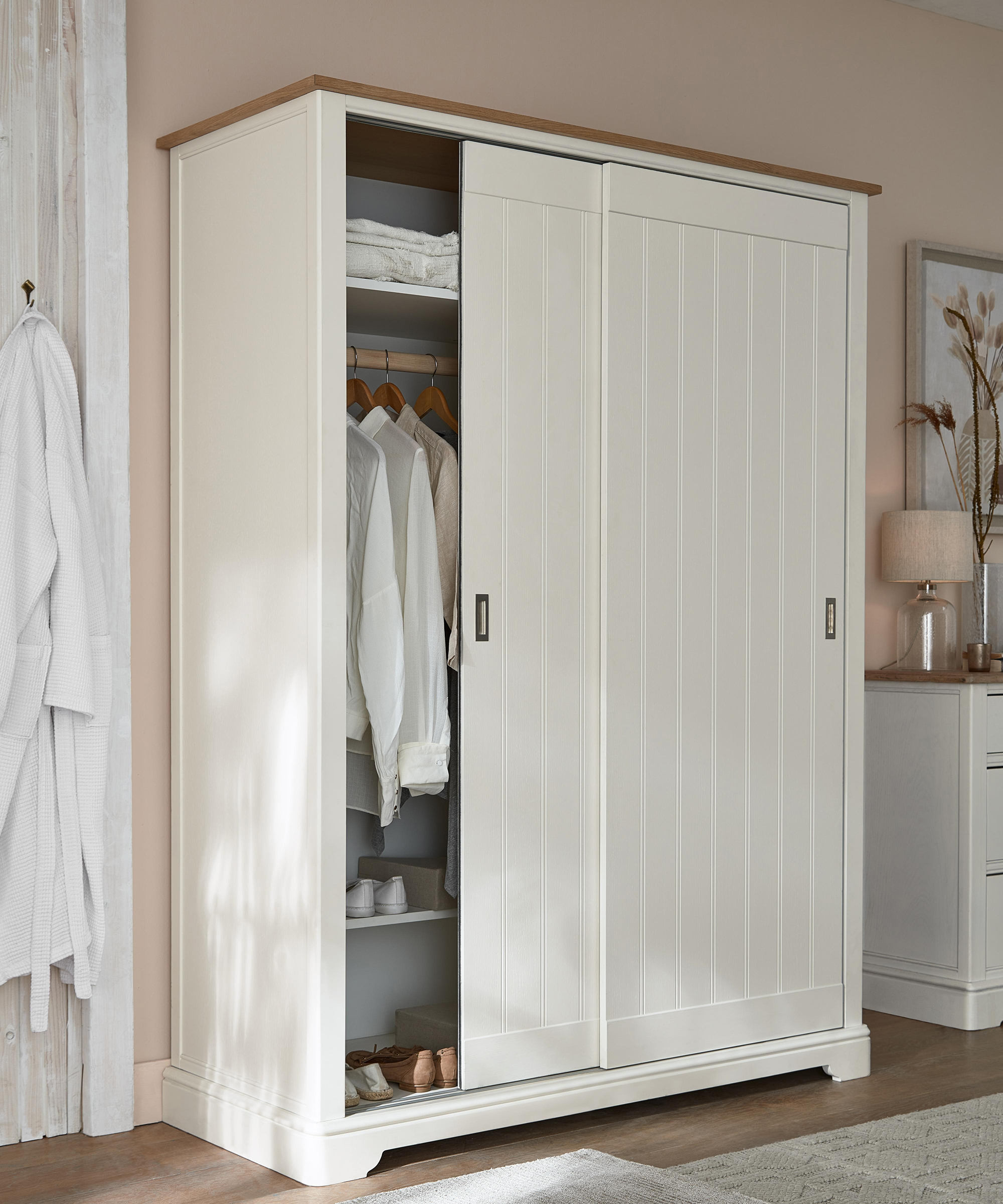 A white master closet wardrobe by Next with shiplap style detail