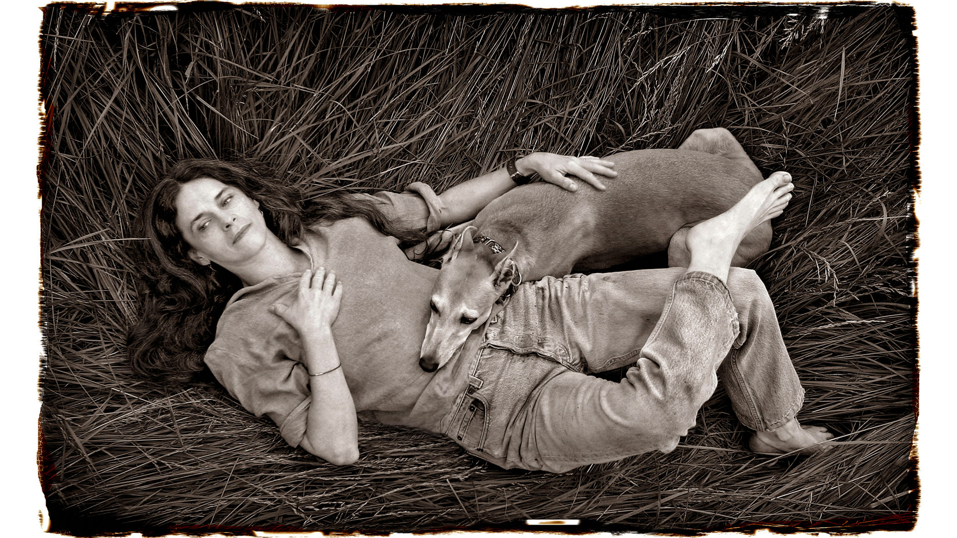 MAY 24 , 2024: Photographer Sally Mann relaxes with her dog "Honey" in a meadow of tall grass on her farm near Lexington, Virginia, USA. (Photo by Michael Williamson/The Washington Post via Getty Images)