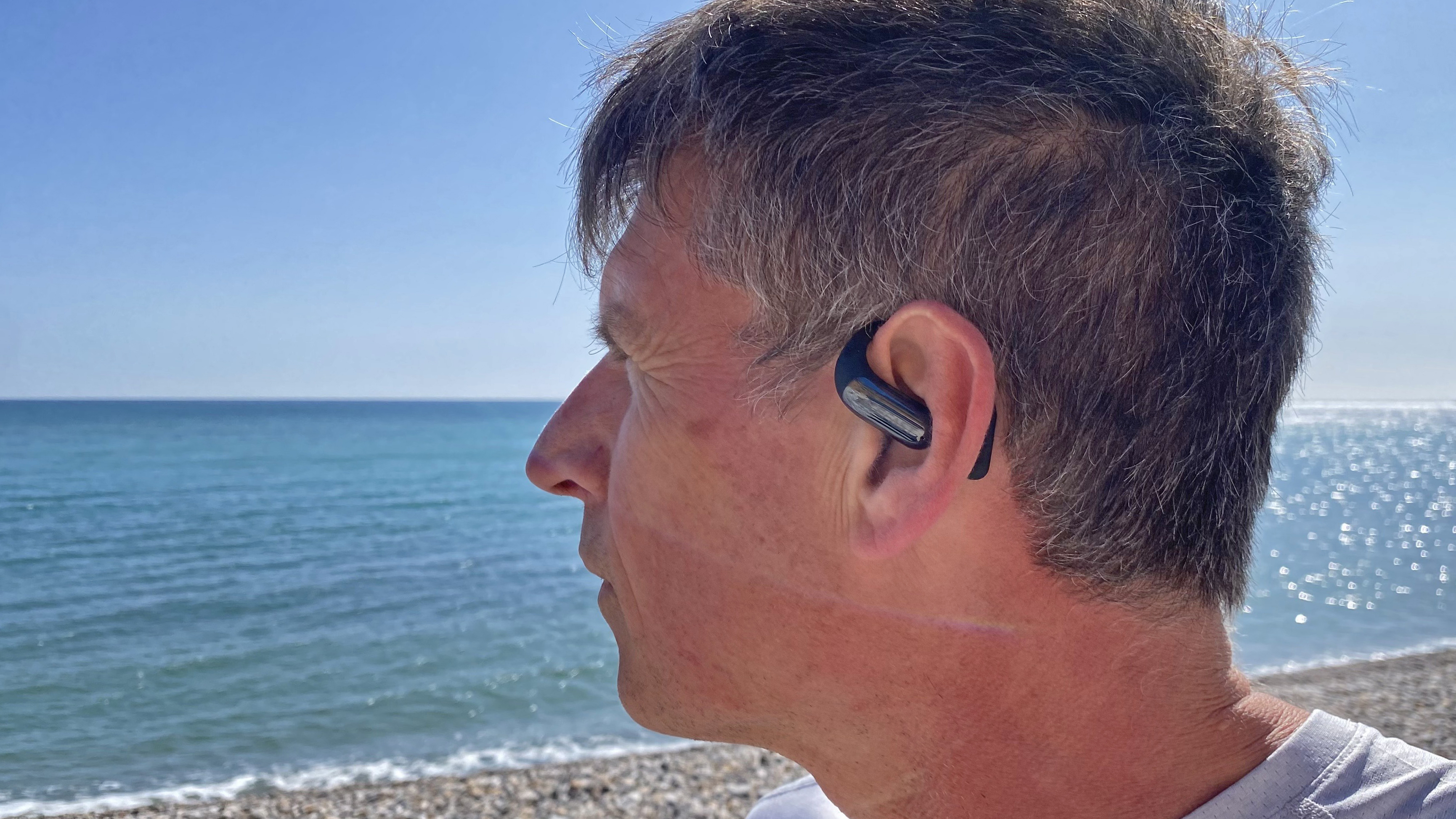 Runner wearing the AceFast AceFit Earbuds with the sea in the background