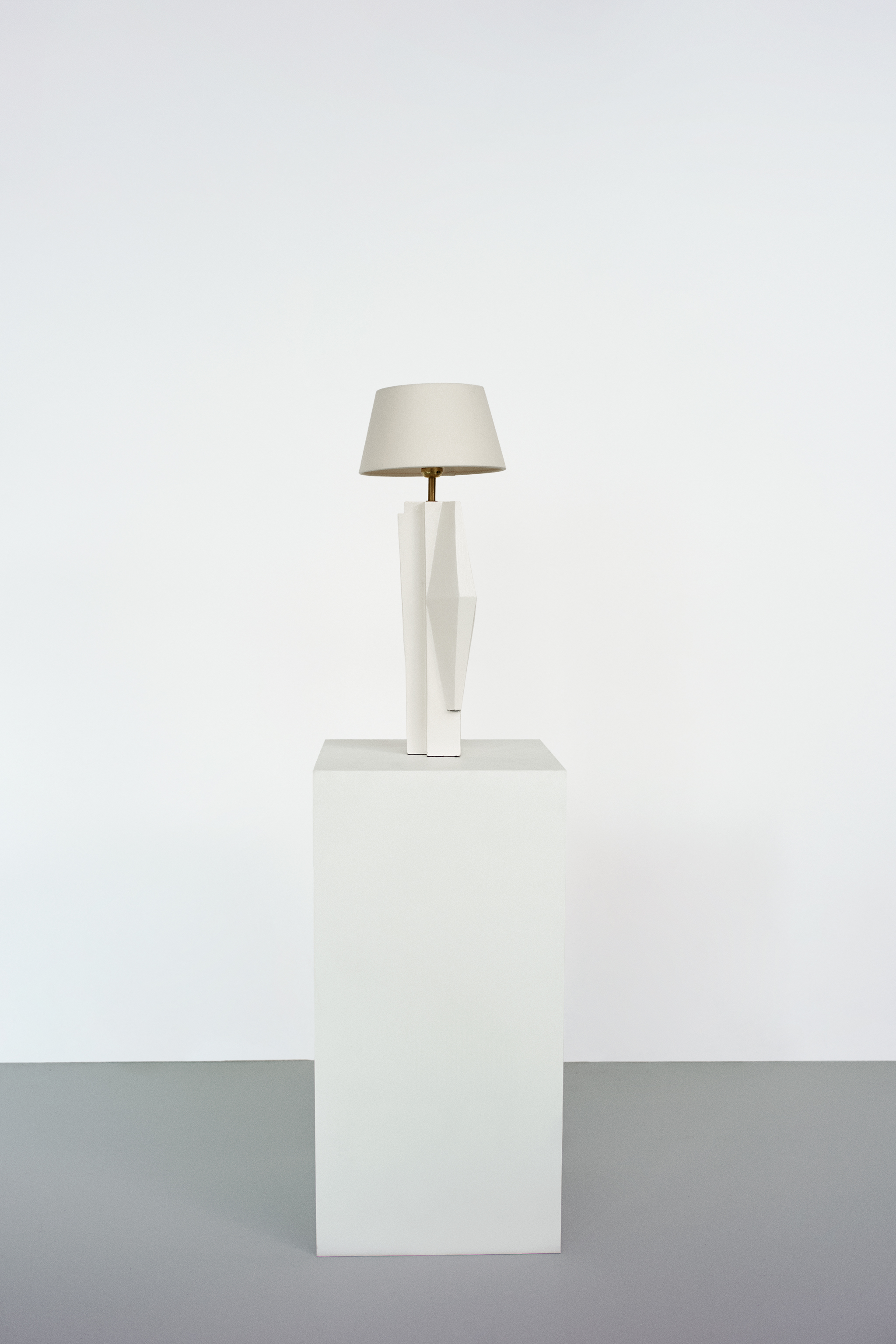 Lamp with a geometric ceramic base and a conical lampshade