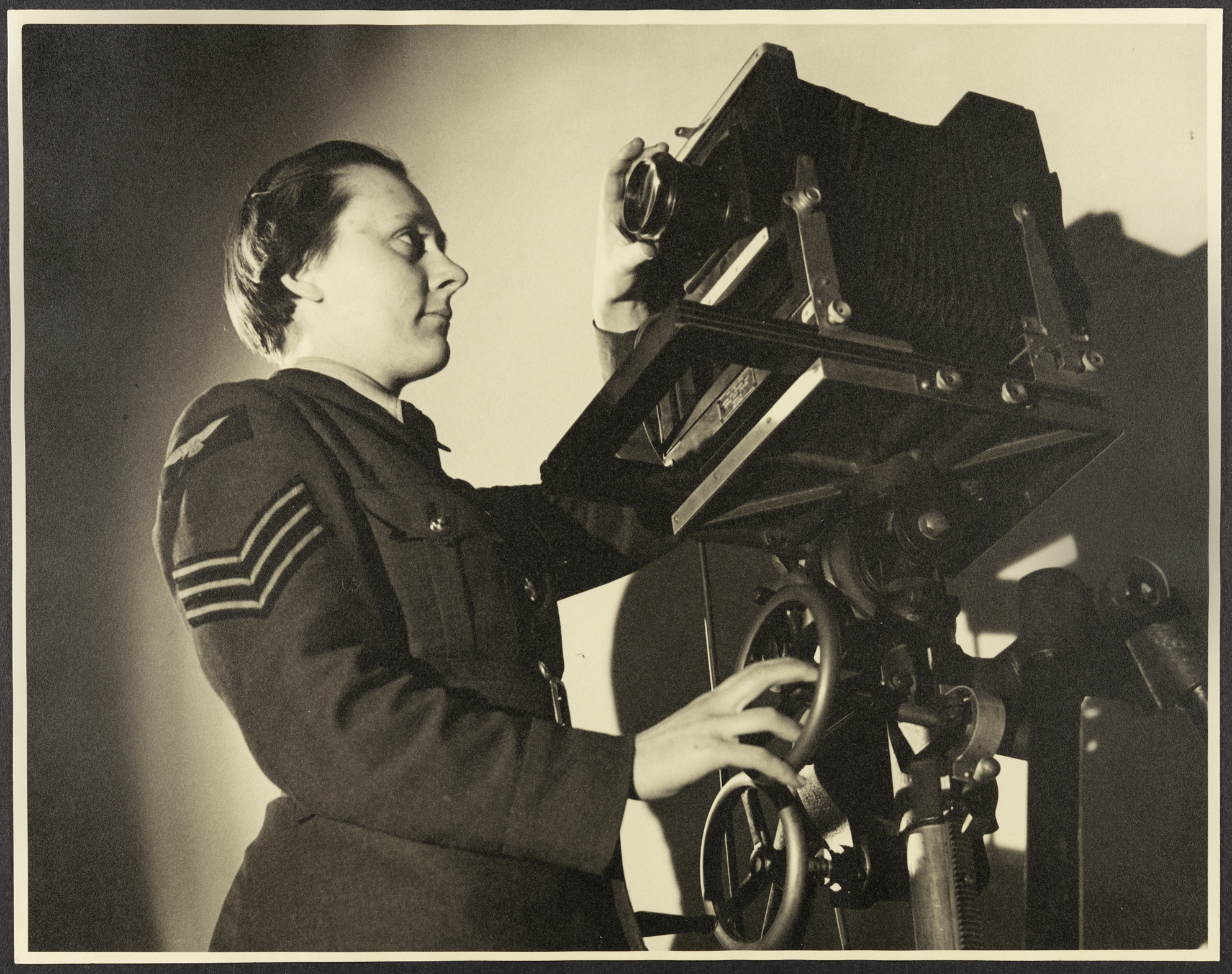 Portrait of WAAF Sergeant Knicky Knapman (later Chapman) with Walter Bird's camera, at RAF Iver Heath (Pinewood Studios)