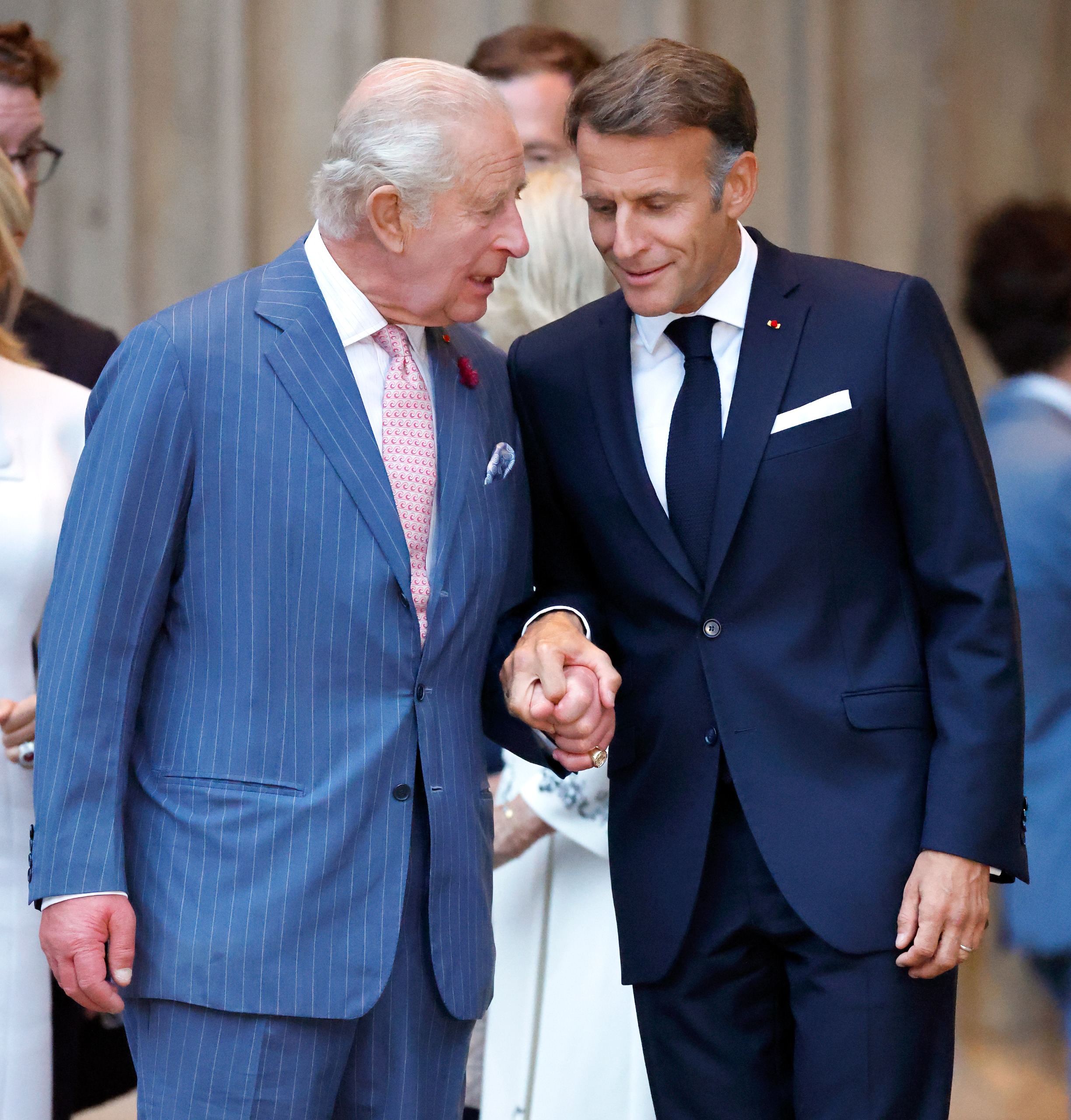 King Charles and Emmanuel Macron holding hands