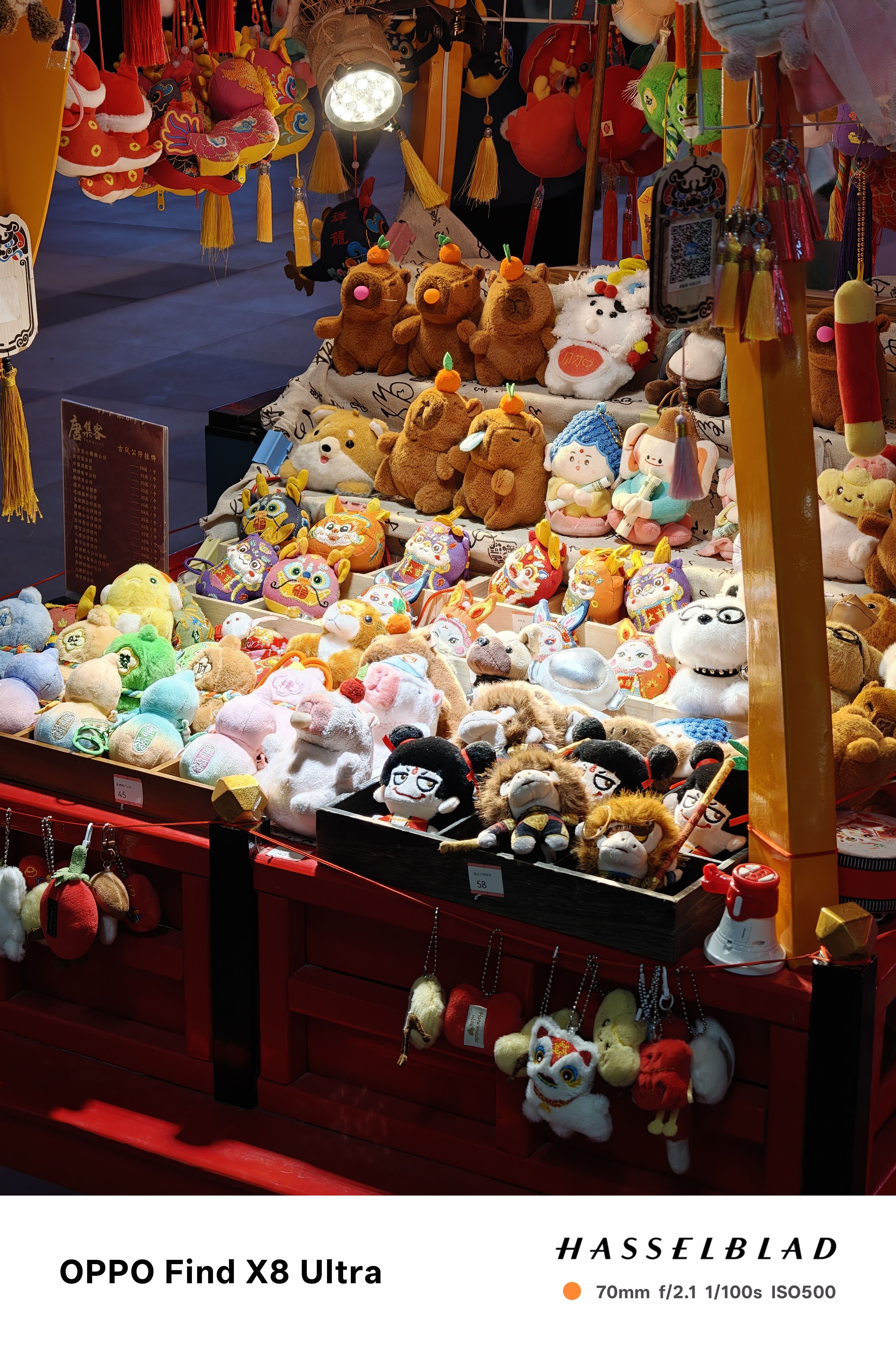 Stuffed toys lit up at night on s stand on the street