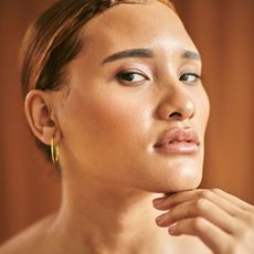 best bronzing drops Woman with golden toned makeup GettyImages-1438686217