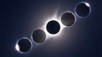 A composite image of 5 sun/moon conjunctions showing the stages of a total solar eclipse arrayed in a diagonal line in a dark sky, with the point of maximum eclipse in the middle.