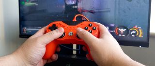 A photo of the orange GameSir Tarantula 8K controller being used to play Call of Duty: Black Ops 7