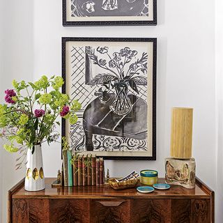 white hallway with pictures and flower vase