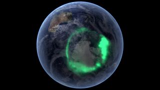 A view of the entire planet with a green, ring-shaped aurora around the south pole