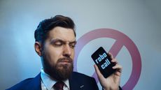 Man looking at phone robocall written on it.
