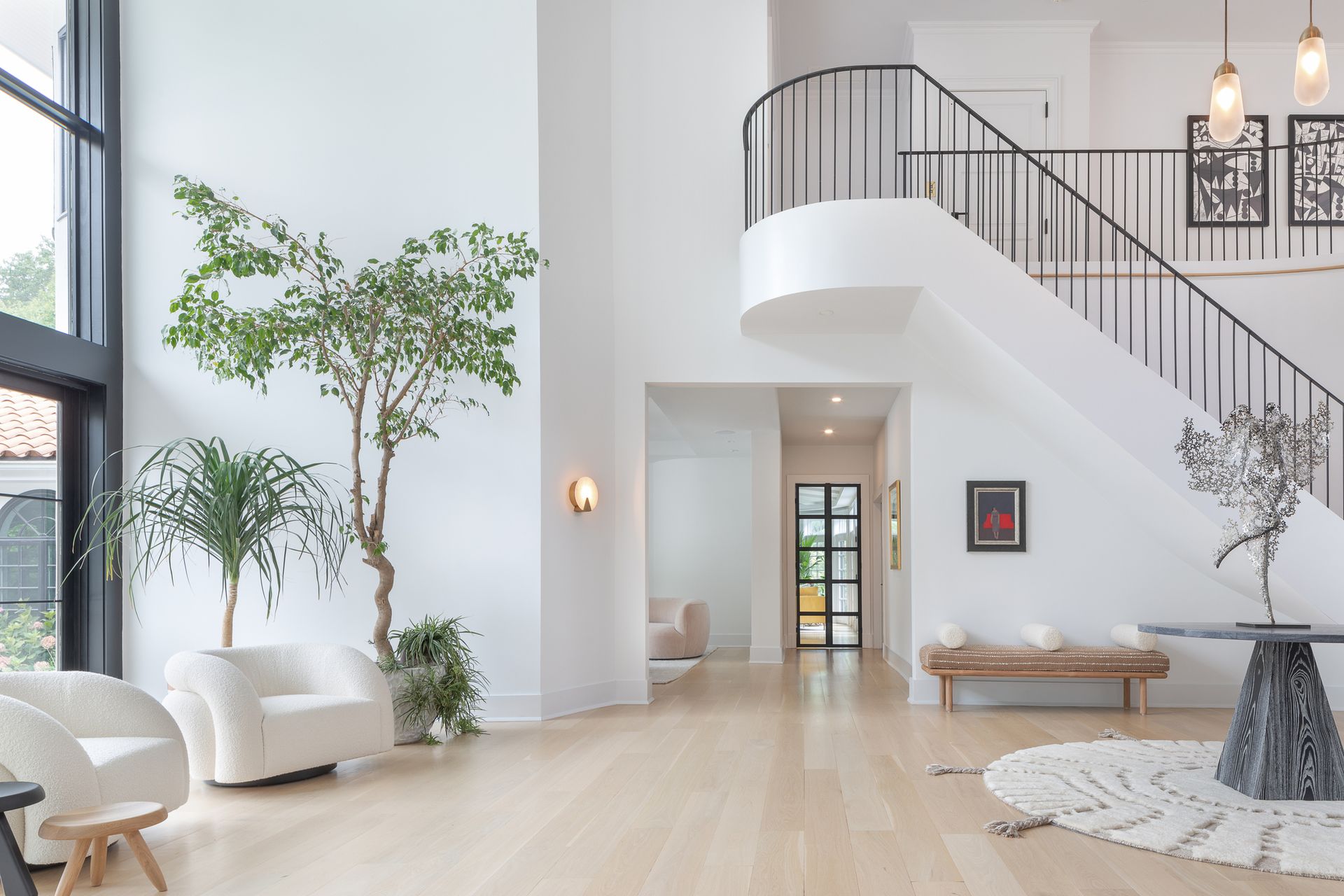 A foyer with white walls and rich materials