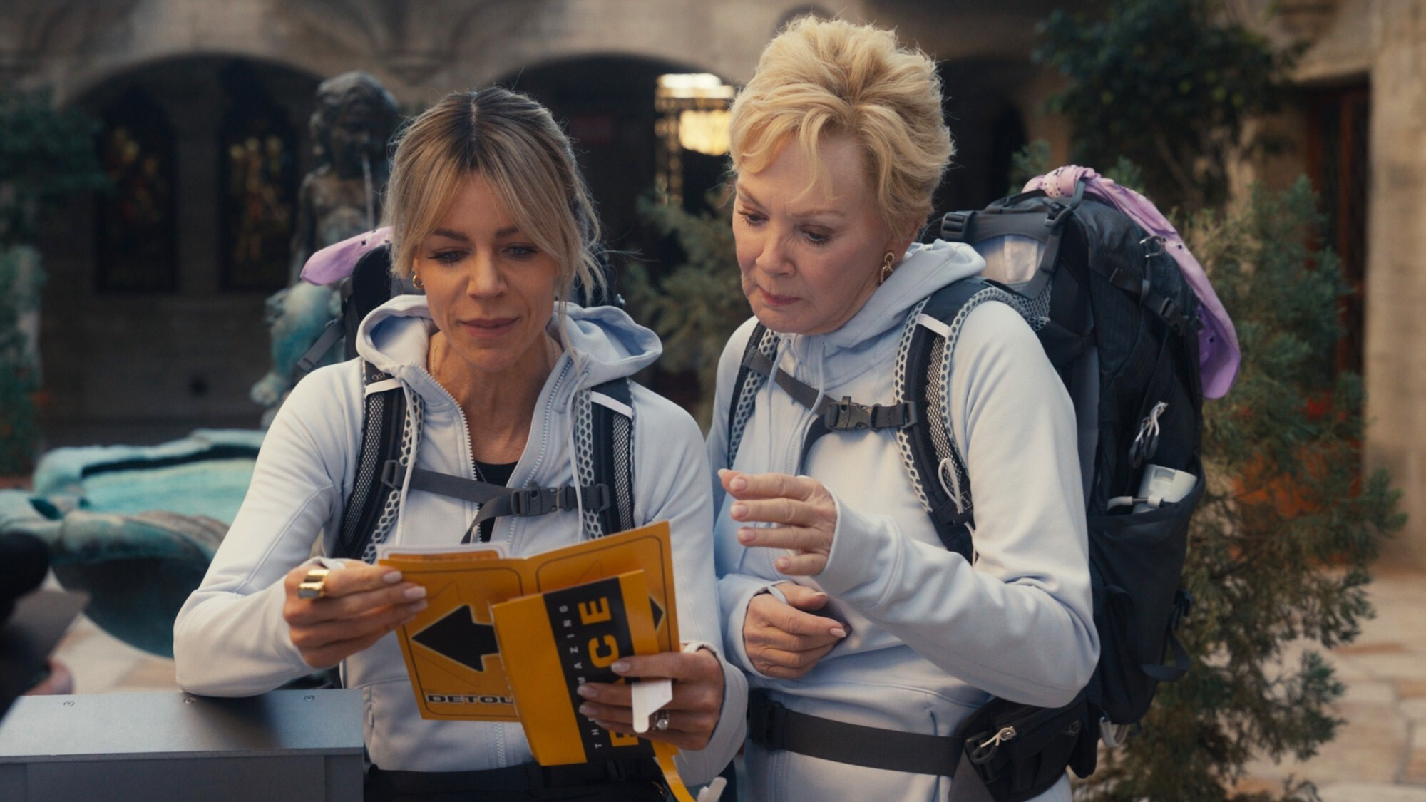 Kaitlin Olson and Jean Smart compete in matching grey hoodies on The Amazing Race season in Hacks.