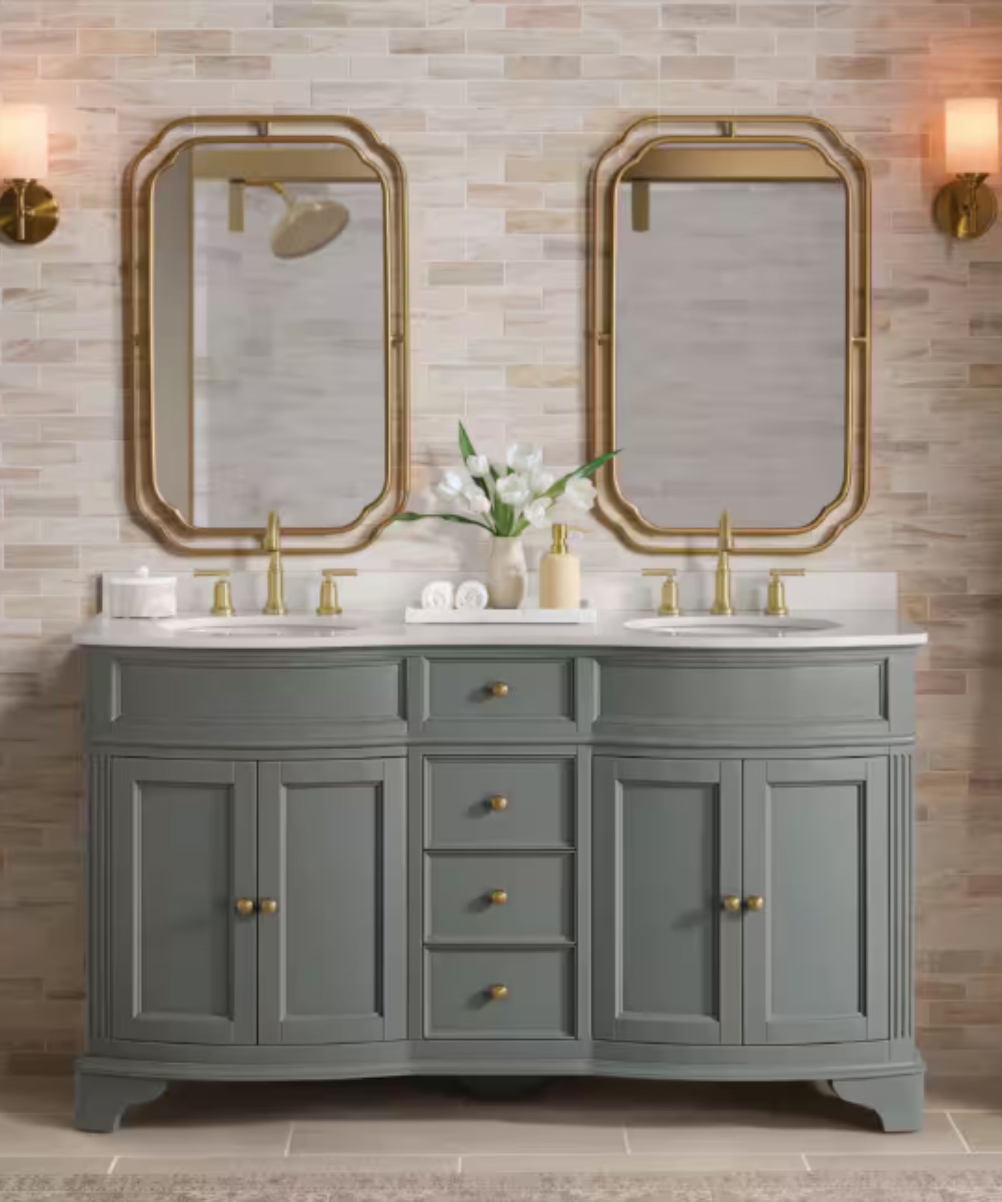 A gray bathroom vanity with a white countertop paired with gold faucets and gold mirrors