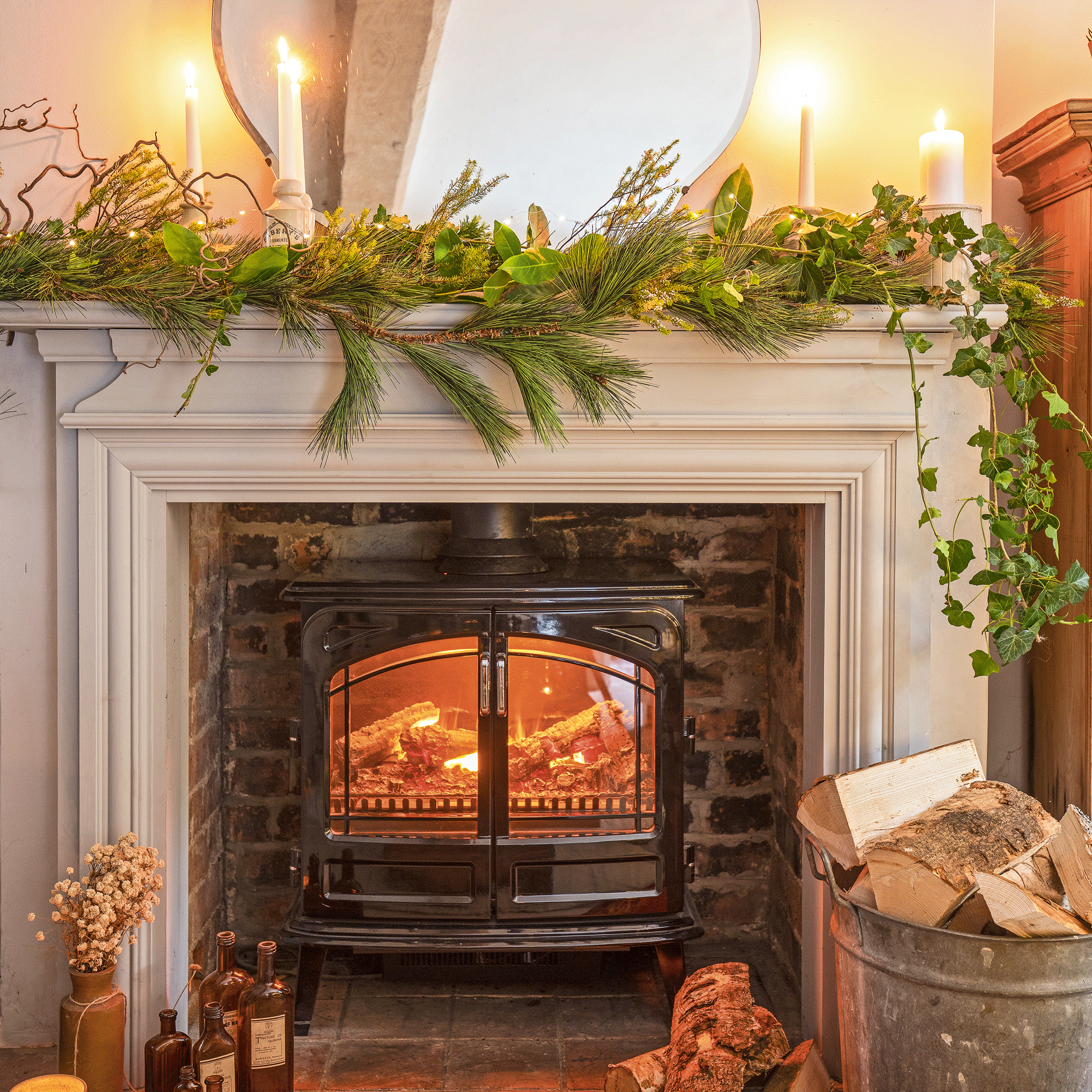 a fireplace surround with a faux woodburner decorated for Christmas