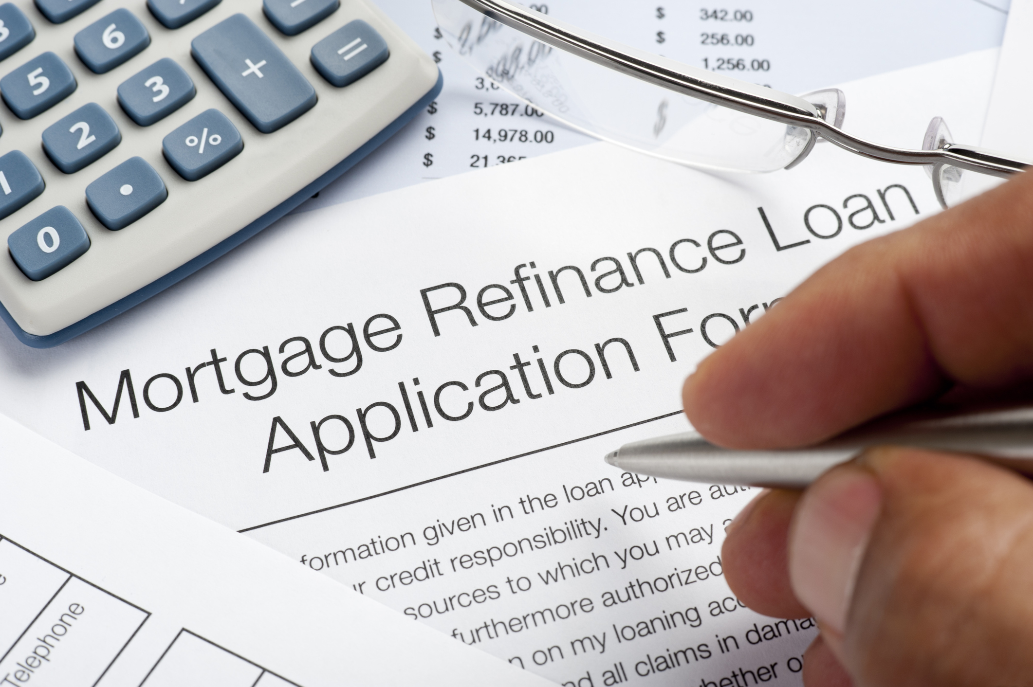 Mortgage Refinance Application Form with pen and calculator