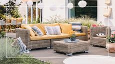picture of rattan outdoor sofa set with yellow cushions in garden