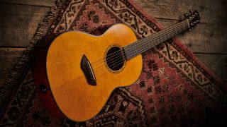 A Yamaha CSF-TA nylon string acoustic guitar lying on a rug