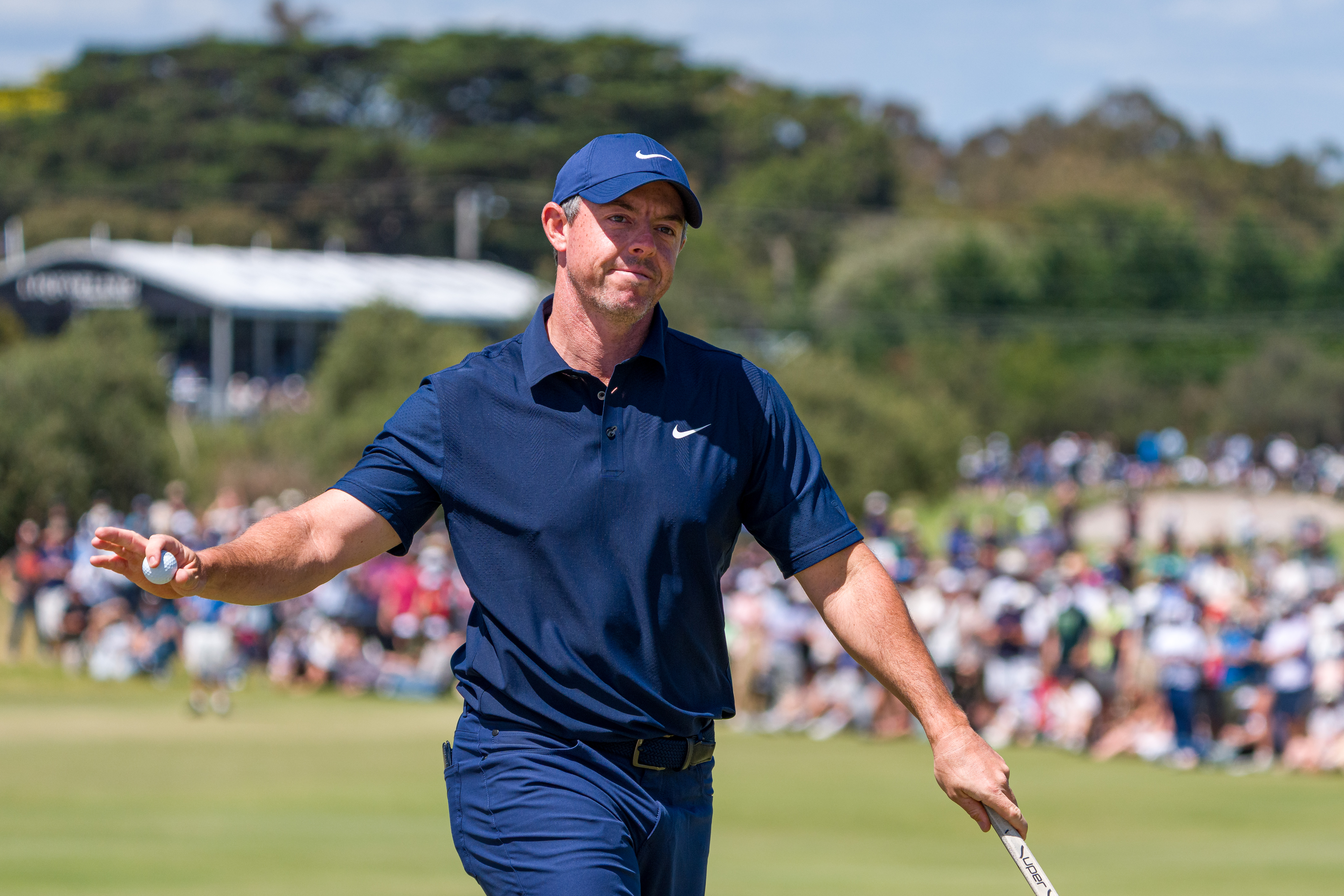 Rory McIlroy waves to the crowd after holing a putt