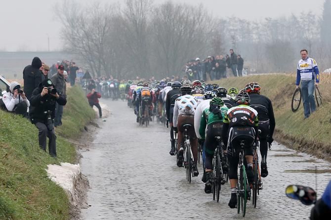 The peloton strung out through the gloom in the race across Flanders