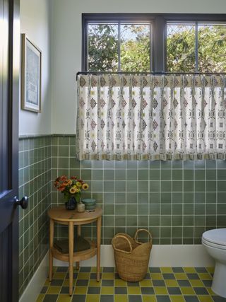 powder room with green tiles and checkered floor tile and cafe curtains