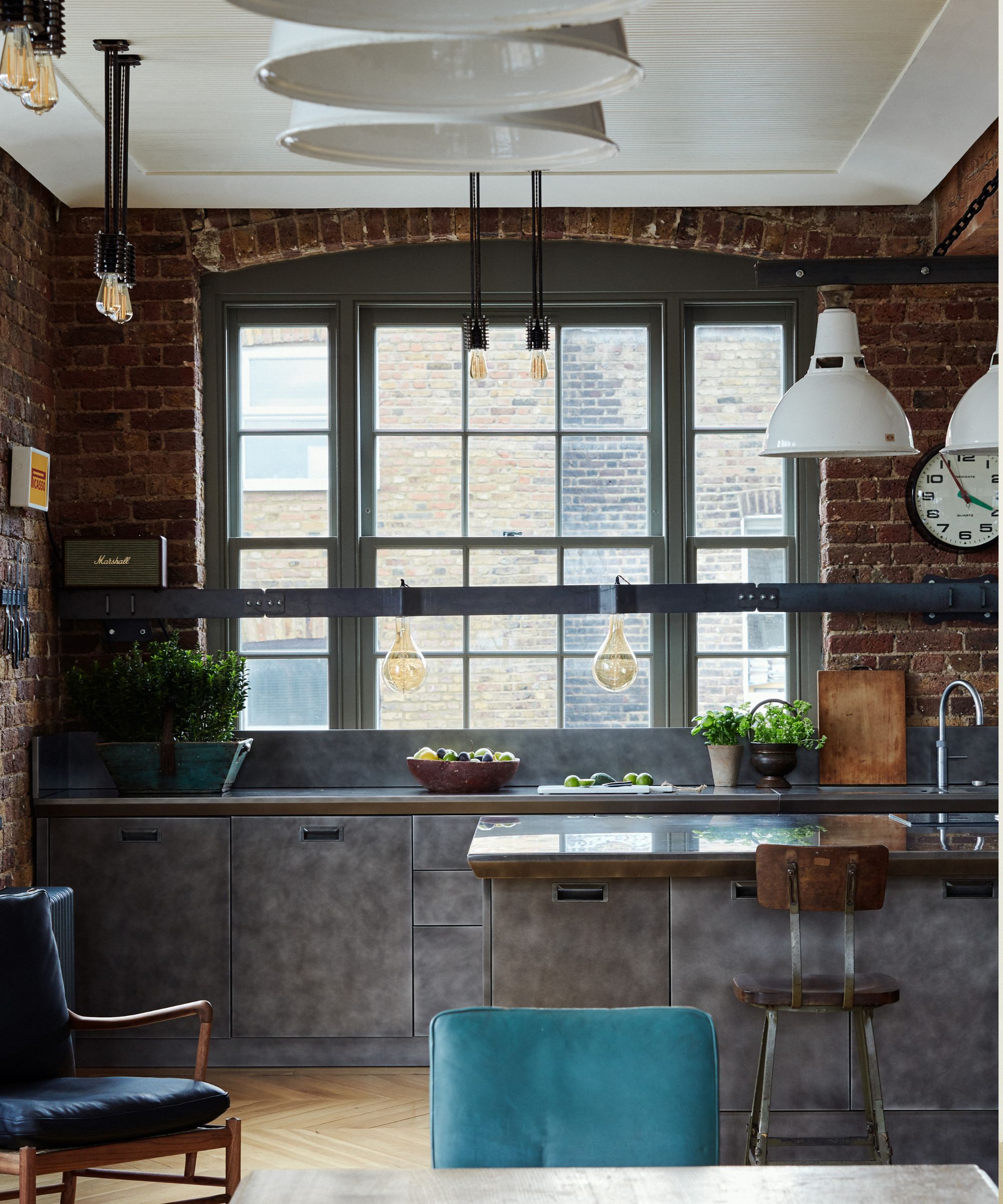 Industrial kitchen with metal cabinets in a red brick urban apartment