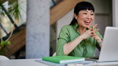 Woman talking to video call, sitting at desk smiling