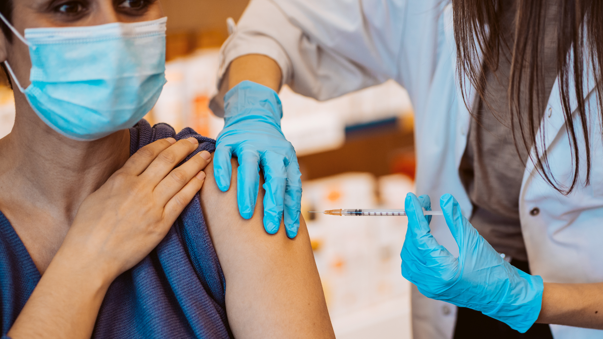 Woman receiving a vaccine from a doctor.
