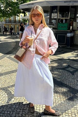 Rita Montezuma wearing a stripe shirt and white skirt