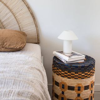 Woven basket utilized as bedside table.