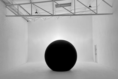 A sphere-like Xydrobe portal in a plain white room