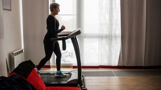 Woman walking on a treadmill at home in living room