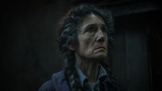 An old woman with braided hair in anguish