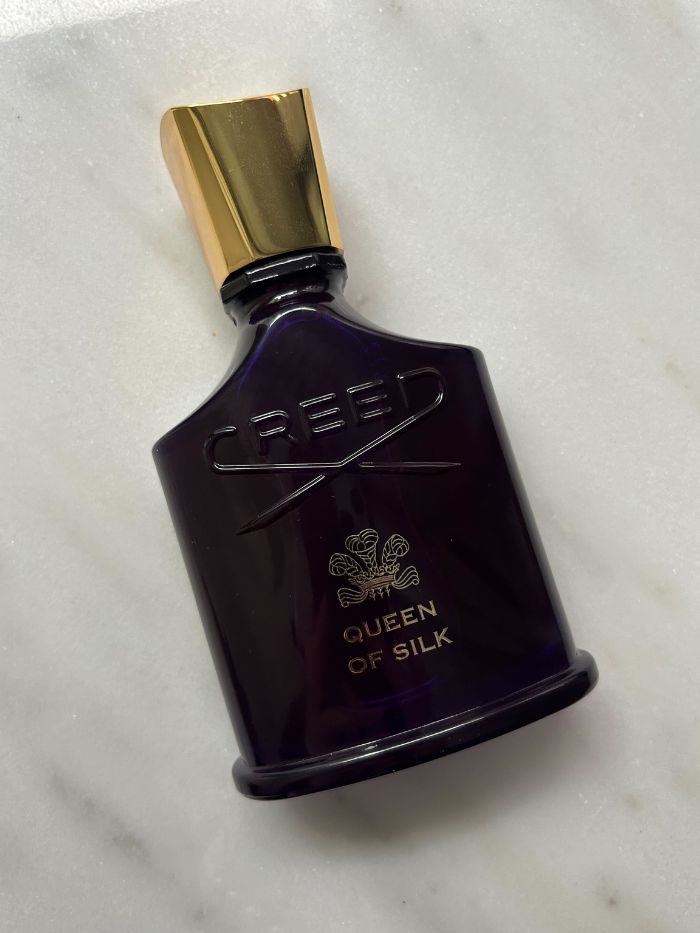 A picture of a Creed perfume on a marble background
