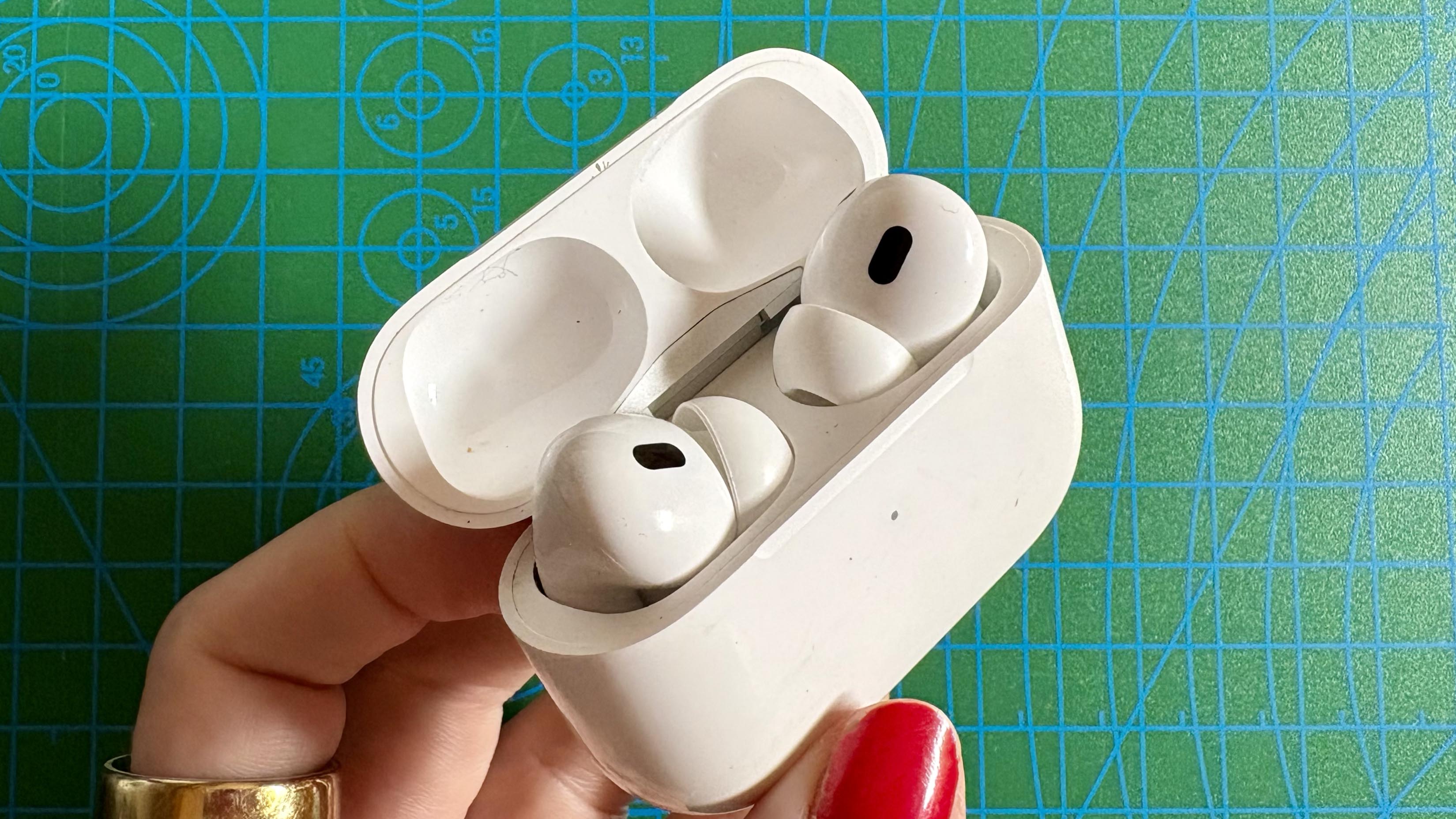 Person holding the Apple AirPods Pro 2 in the charging case
