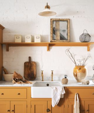 A white kitchen with warm wooden cabinetry designed by deVOL