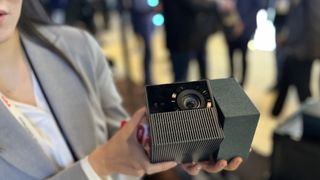 TCL PlayCube held in presenter's hands at CES