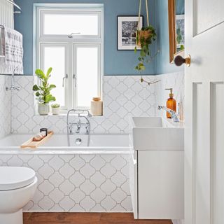 Bathroom with blue walls and white tiled panel bath