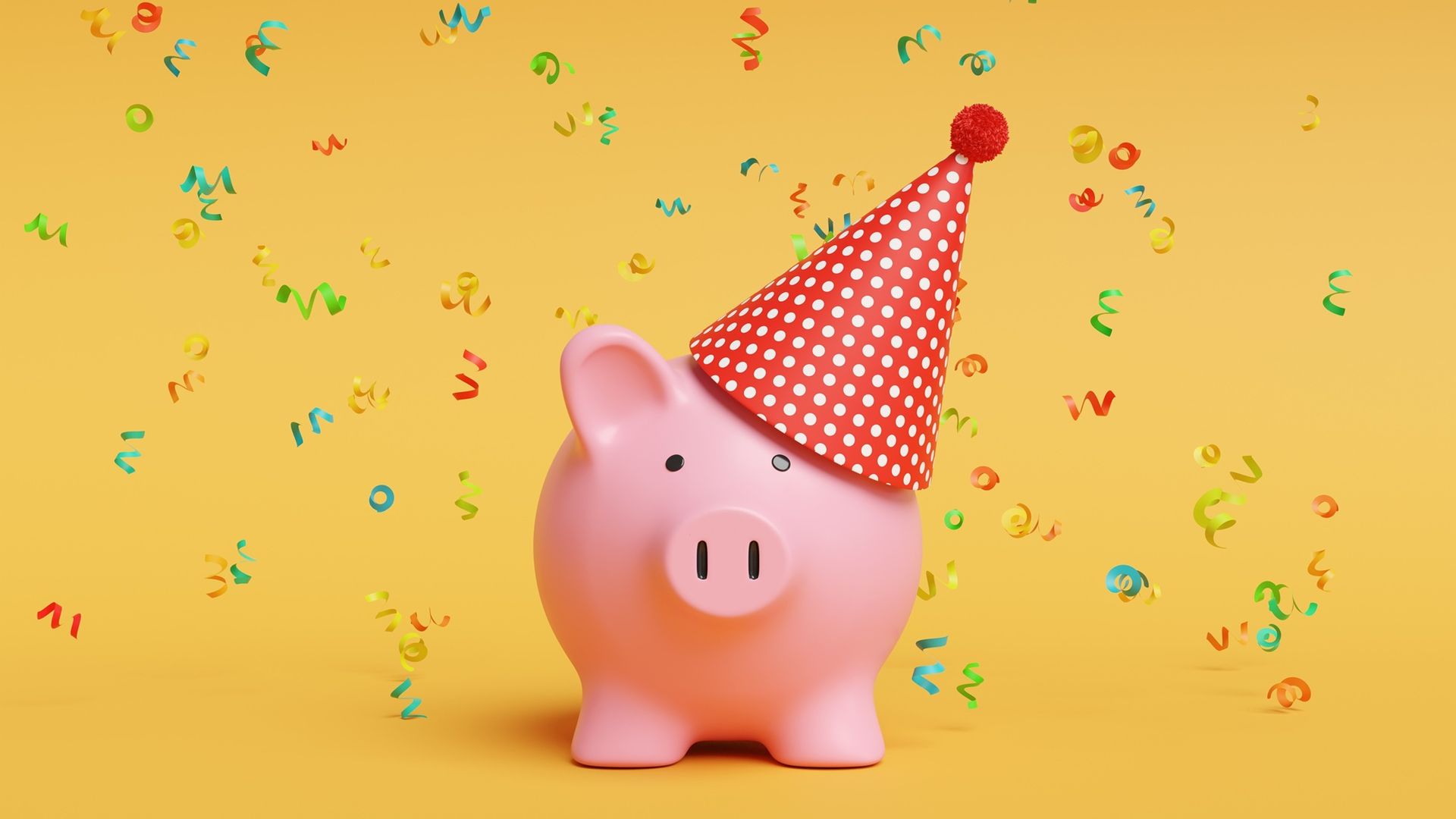 Confetti falling on a piggy bank wearing a party hat.