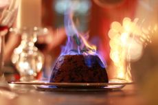 Close up of Christmas pudding on fire at the Christmas dinner table
