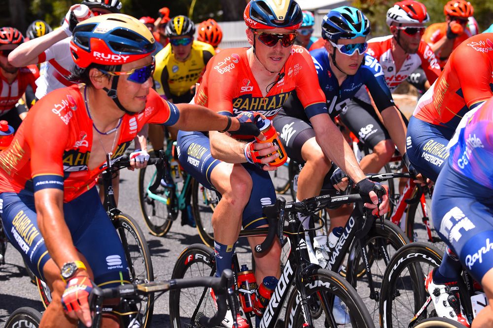 Rohan Dennis gets a bidon from a Bahrain-Merida teammate