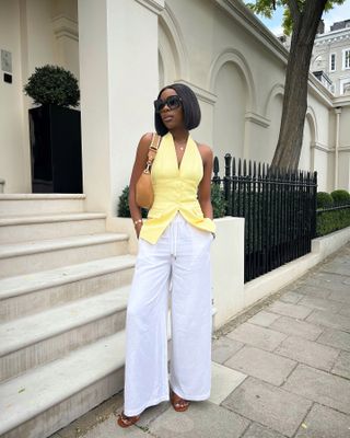 Tops to wear with wide-leg trousers: @tostos_ wears a yellow vest with white trousers