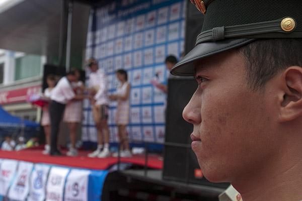 Spains Arkaitz Duran (Footon Servetto) is presented with his Polka-Dot jersey but that doesn't faze one of the local servicemen in Dongfang.