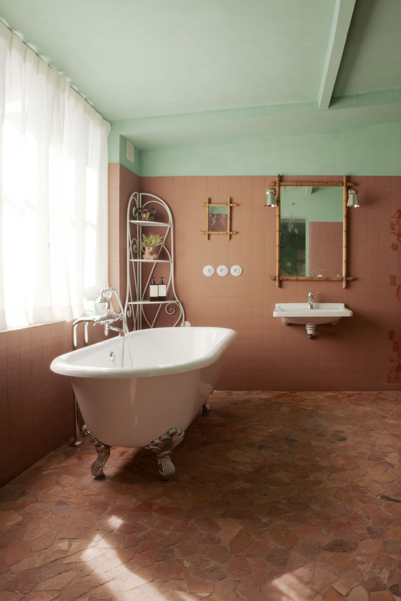 A whimsically designed hotel boasts richly layered interiors characterized by hand-drawn, fantastical mural motifs, earthy and pastel shades, and shapely furniture.