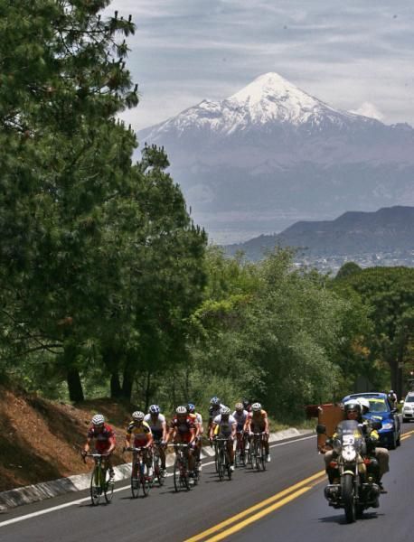 Snow capped peaks loom behind the riders.