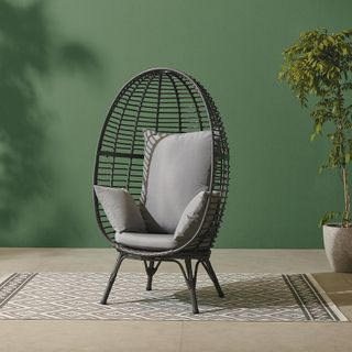 egg chair with green wall and carpet