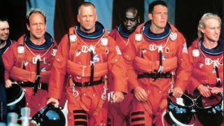 four actors in astronaut suits walking in line