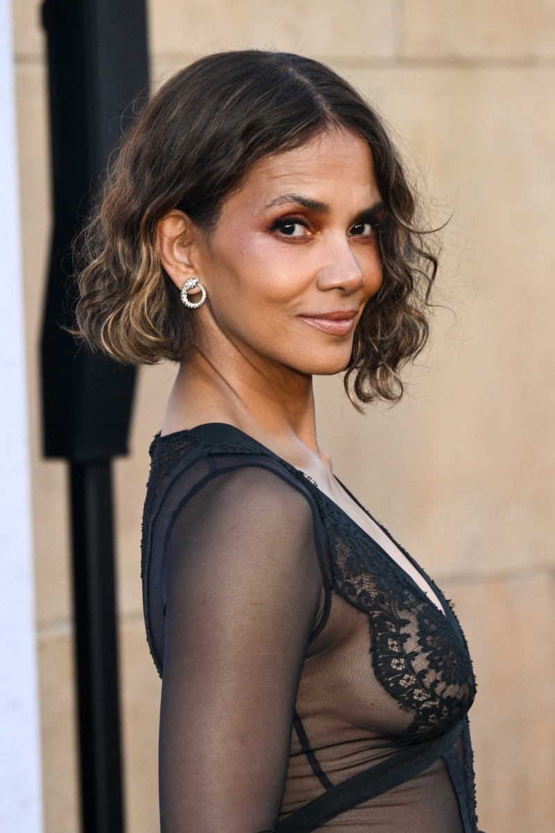 Halle Berry is pictured with a cool bronde curly bob hairstyle and wearing a black mesh dress at the premiere of "The Union" held at The Egyptian Theatre Hollywood on August 12, 2024 in Los Angeles, California.