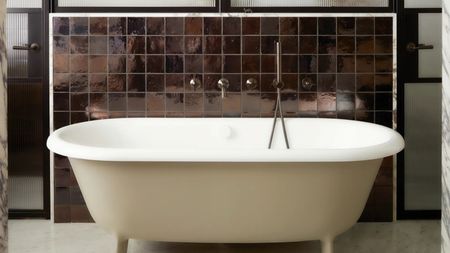 a bathtub painted beige with a brown zellige tile backsplash