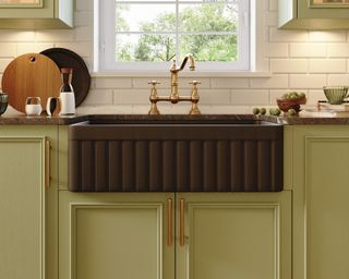 Green kitchen cabinets with black sink