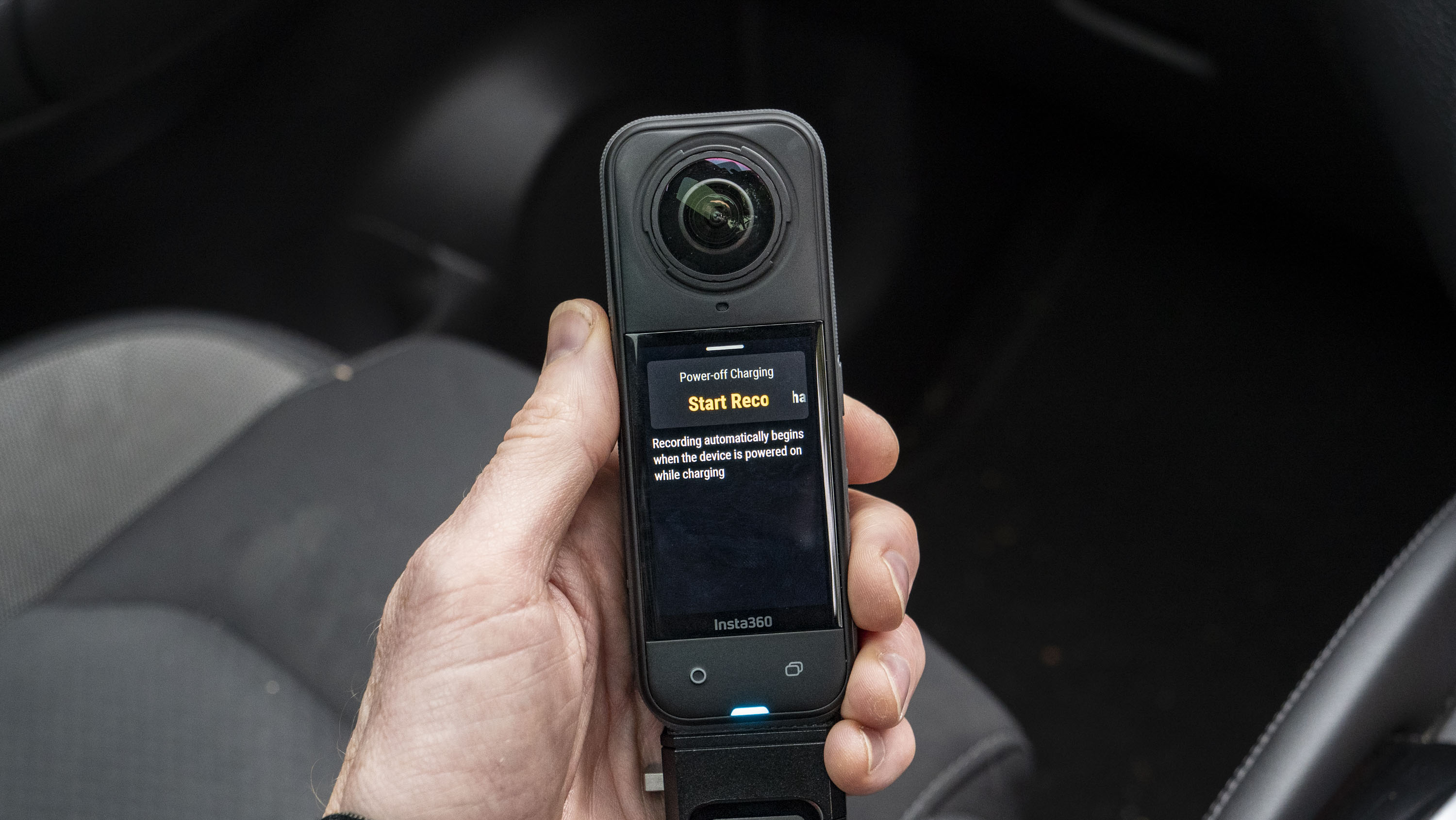 Insta360 X5 inside a car in user's hand, with loop recording options on the display